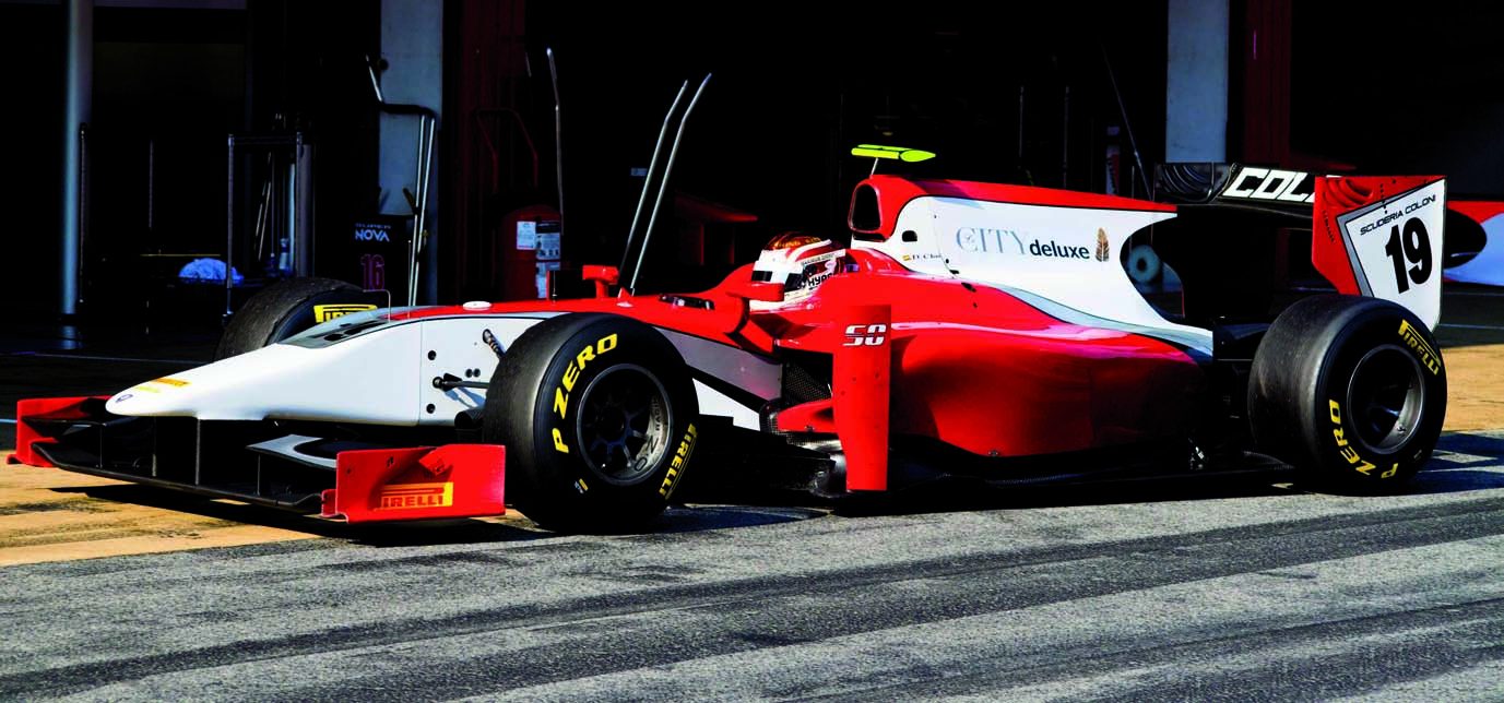 The red and white Scuderia Coloni GP2 car number 19 in the pit lane, with the Le CITY deluxe logo on its engine cover.
