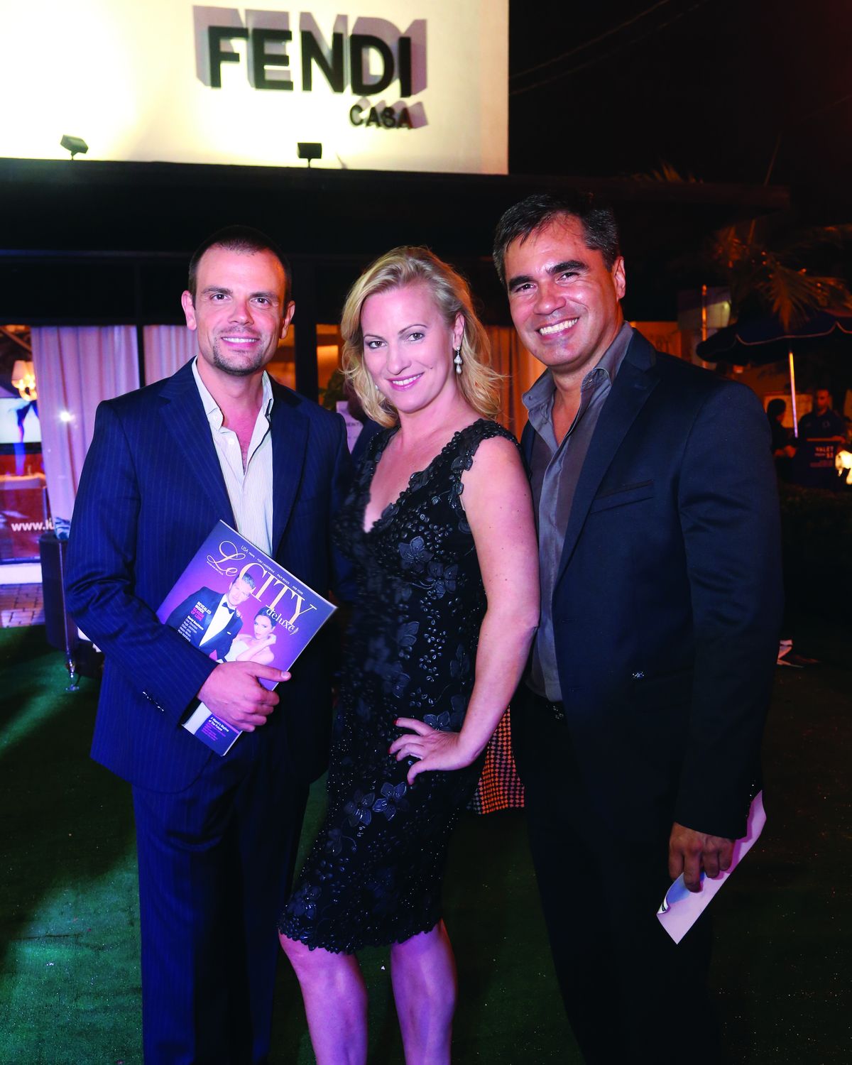 Dame Claudia Trimde at Fendi Casa in Miami with two guests, one holding the Le CITY deluxe issue